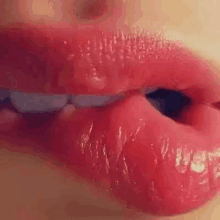 a close up of a woman 's lips with red lipstick and a kiss .