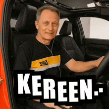 a man wearing headphones is sitting in the driver 's seat of a car with the word kereen written on it