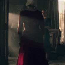 a woman in a red dress is standing in a room