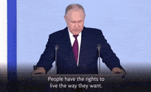 a man in a suit and tie stands behind a podium with the words " people have the rights to live the way they want "