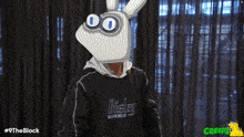 a person wearing blue gloves and a biser sweatshirt