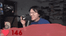a pixelated image of a man holding a camera with the number 146 in red letters