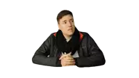 a man wearing a scarf and a columbia jacket is sitting with his hands folded