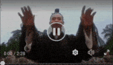 a man with his arms outstretched is playing a video with a pause button in the middle of the screen .