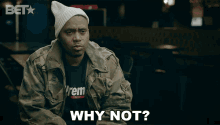 a man wearing a beanie and a jacket says why not