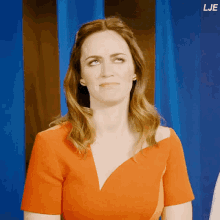 a woman in an orange dress is making a funny face and the word lje is on the bottom