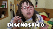 a woman wearing glasses and a tie dye shirt says diagnostico in spanish