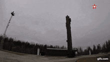 a rocket is being launched into the sky with a red star on it .