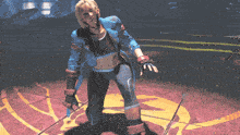 a woman in a superhero costume is kneeling on the ground