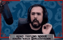 a man with a beard and headphones is sitting in front of a microphone and making a funny face .