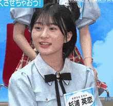 a girl in a blue shirt has a name tag with chinese writing