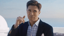 a man in a suit has a netflix logo on the bottom