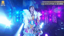 a woman in a colorful dress stands in front of a sign that says fpw_mg on it
