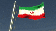 a red white and green flag with a red circle in the middle is flying in the wind