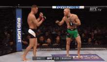 two men are fighting in a boxing ring with a bud light banner