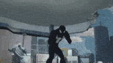 a man in a black spiderman suit is standing in a room