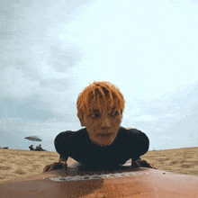 a man with orange hair is laying on a surfboard that says ' o'neill ' on the side