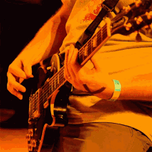 a person is playing a guitar with a wristband that says ' a ' on it