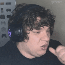 a man wearing a pair of headphones with a purple logo that says razer on it