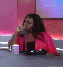 a woman sitting at a table drinking from a mug that says ' ain 't easy '