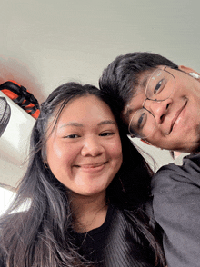 a man and a woman are posing for a picture and smiling