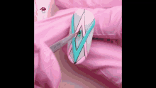 a close up of a person painting a nail with a brush .
