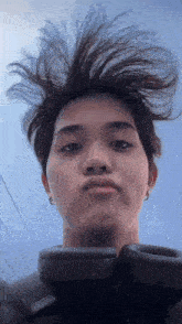 a young man with messy hair is wearing headphones .