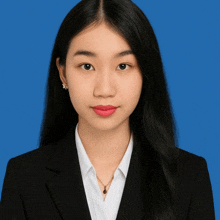 a woman wearing a black suit and white shirt with red lipstick