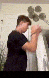 a man in a black shirt is standing in a room