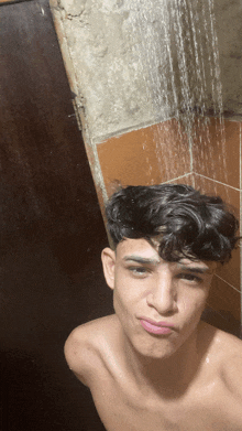 a young man taking a selfie under a shower head