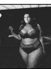 a black and white photo of a woman in lingerie with the word ouji written on the blackboard behind her