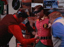 a man in a robin costume is being held by two men