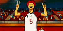 a volleyball player with the number 5 on his shirt is giving the middle finger in front of a crowd of people .
