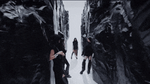 a group of women are walking through a tunnel of black and white walls