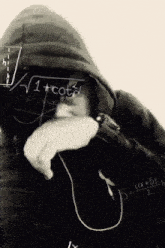a black and white photo of a person covering their face in front of a chalkboard with equations on it