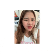 a woman is making a funny face while taking a selfie with her tongue out .