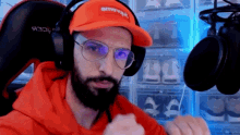 a man with a beard wearing a supreme hat