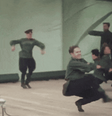 a group of people in green shirts are dancing on a stage