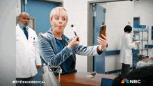 a woman is taking a selfie in a hospital with nbc written on the bottom