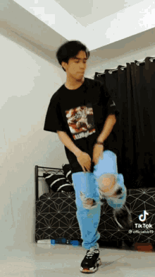 a young man in a black shirt and blue jeans is dancing .