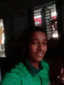 a woman in a green shirt is smiling and looking down