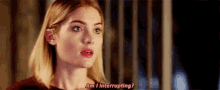 a close up of a woman 's face with the words `` am i interrupting '' written on it .
