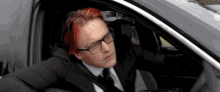 a man with red hair is sitting in a car