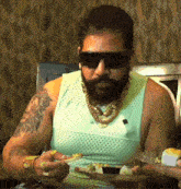 a man with a beard wearing sunglasses is eating