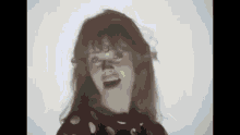 a young girl is making a funny face with her mouth open .