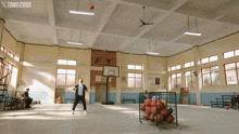 a man is playing basketball in a gym with a sign that says toms 2005
