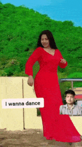 a woman in a red dress is dancing with a man in the background and says i wanna dance