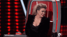 a woman is sitting in a chair with the words #thevoice on the bottom