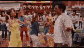 a man and a woman are dancing in front of a crowd of people at a carnival .