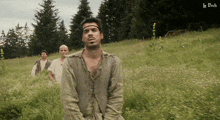 a group of men standing in a grassy field with le bob written on the bottom right